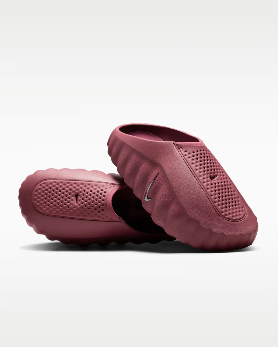 Pair of maroon slippers on a light gray background