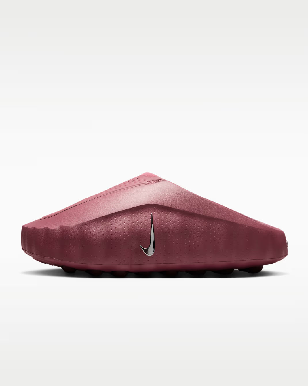 A single Nike slip-on clog in a dusty rose or muted burgundy color, featuring a textured rubber sole and a metallic silver Swoosh logo on the side, set against a clean white background.