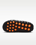 Black sandal with orange buttons on a white background