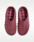 Pair of pink clogs with Nike branding on a white background
